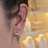 Close-up of an ear with multiple earrings and a blurred background