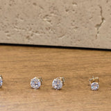 Set of diamond stud earrings on a wooden surface