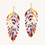 Colorful feather-shaped earrings on a white background