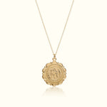 Gold necklace with a round pendant on a white background