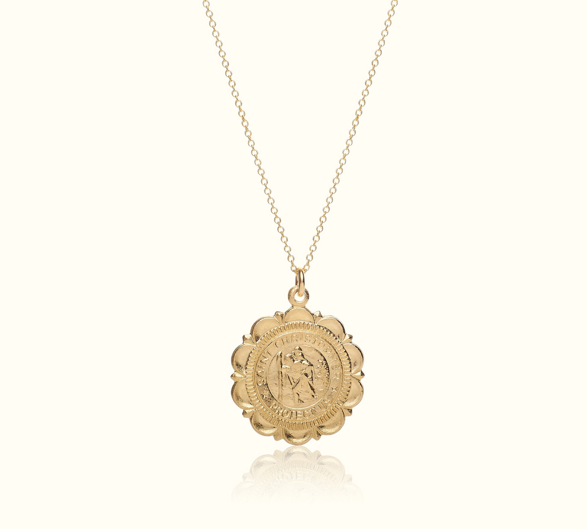 Gold necklace with a round pendant on a white background