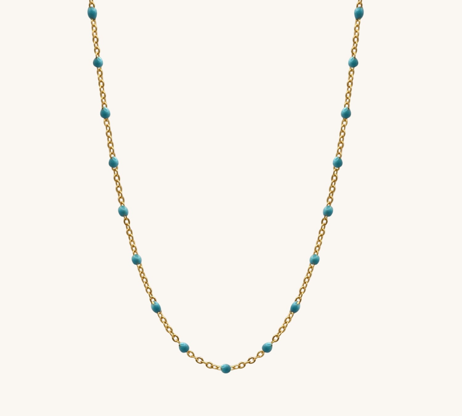 Necklace with gold chain and turquoise beads on a white background