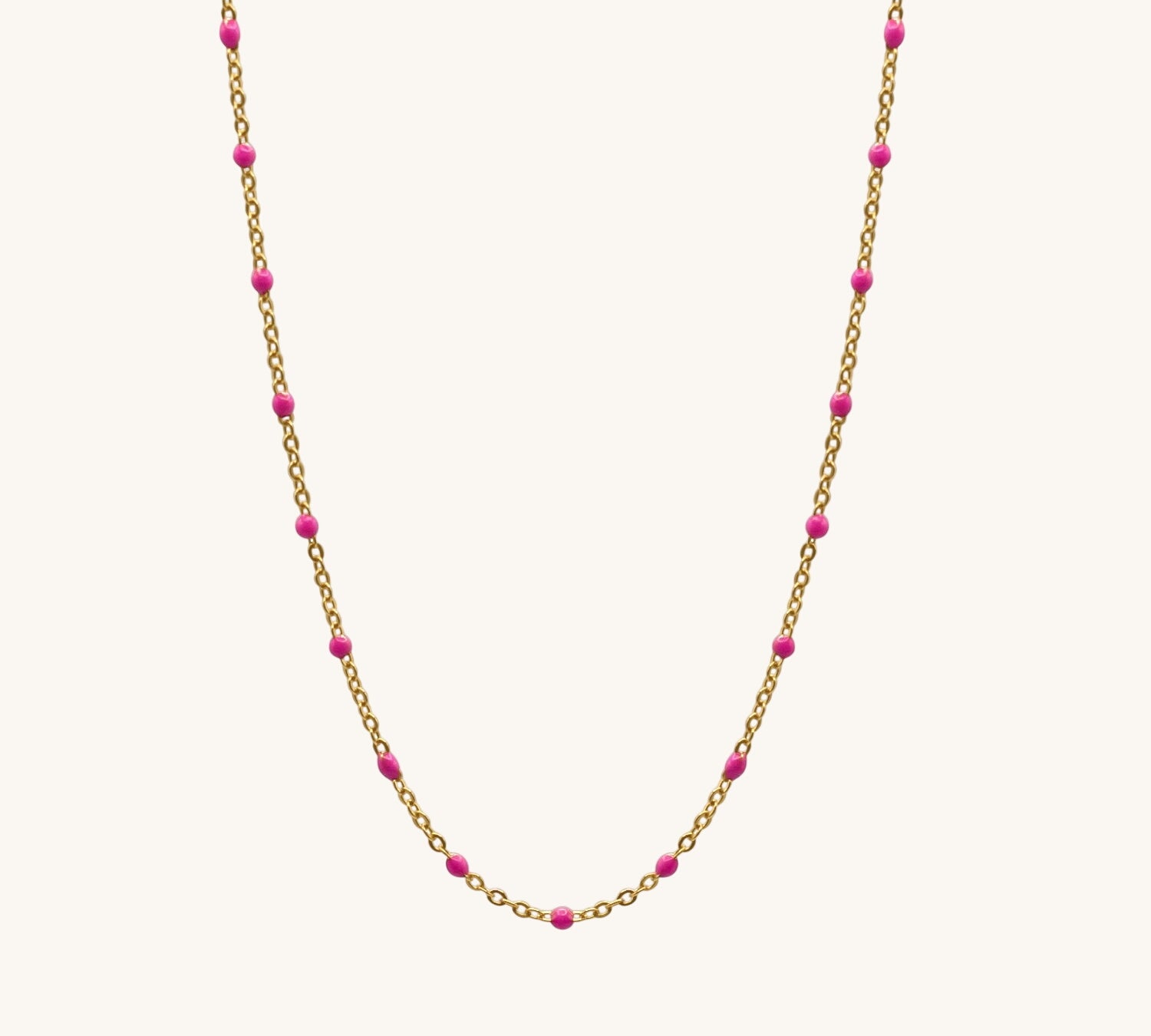 Necklace with gold chain and pink beads on a white background