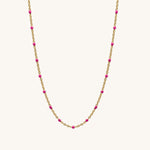Necklace with gold chain and pink beads on a white background
